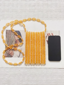 Détail d'un sac de téléphone fait main en perles de cristal ambre et perles blanches
