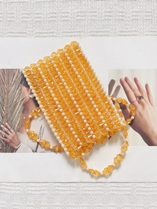 Détail du sac bandoulière artisanal avec perles orange facettées et perles blanches