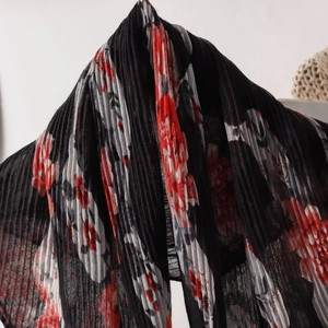 Close-up of pleated floral scarf featuring elegant red and black floral print details