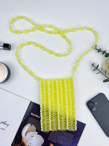 Vue détaillée d'un sac bandoulière en perles jaunes pour téléphone portable