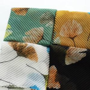 Macro detail of pleated ginkgo leaf print scarves in four elegant fashion colors