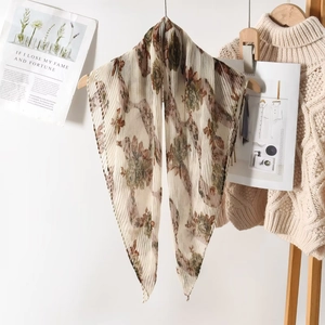 Lightweight pleated floral shawl with vintage print hanging on a wooden hanger
