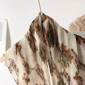Close-up of pleated floral scarf showing light breathable fabric and vertical crinkle texture