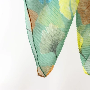 Close-up of pleated ginkgo leaf print fabric with fine stitching for summer shawl