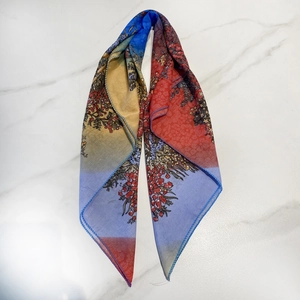 Détail du foulard ethnique dégradé arc-en-ciel avec imprimé floral et texture soyeuse