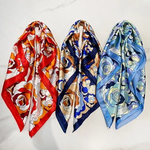 Detailed flat lay of three luxury satin square scarves with retro rose floral prints