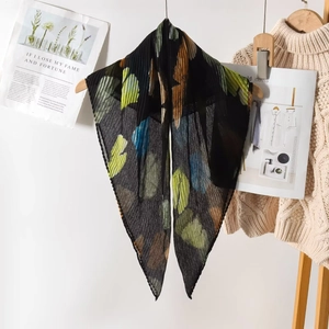 Detail of pleated black scarf with colorful leaf prints and lightweight crinkle texture