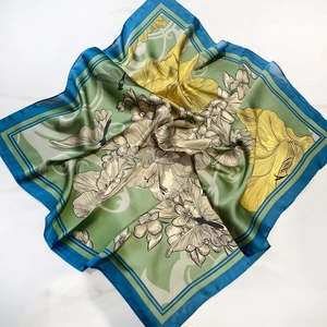 Detailed view of floral silk scarf with dragonfly pattern on marble background