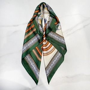 Forest green and gold chain print silk scarf on marble background for elegant styling