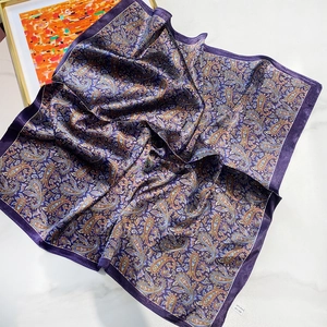 Dettaglio del foulard in seta viola paisley che mostra texture e composizione