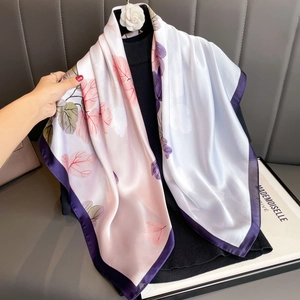 Elegante sciarpa in seta floreale rosa e viola drappeggiata su un dolcevita nero