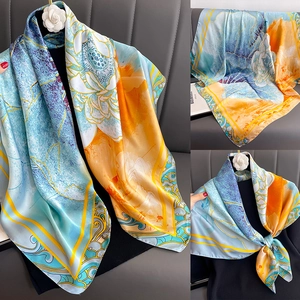 Elegant 90x90cm lotus floral silk scarf in teal and orange used as a stylish shawl