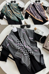 Detail of green houndstooth print scarf with Fashion Modern text on black fabric