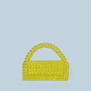 Detail of yellow handmade beaded trapezoid handbag with woven texture and top handle