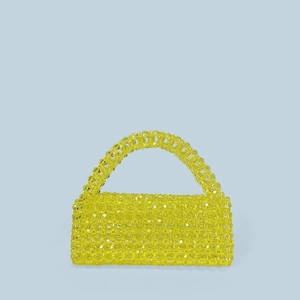 Macro detail of glossy yellow acrylic beads on the handmade woven trapezoid handbag