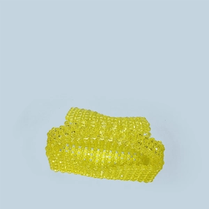 Detail view of the yellow hand-beaded acrylic woven hair claw clip on light blue background