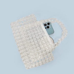 Detail view of transparent beaded handbag with white inner pouch showing storage capacity