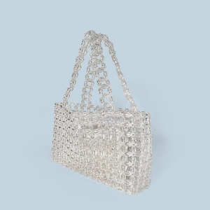 Detail of handmade clear crystal beaded tote bag with white inner pouch and woven handles