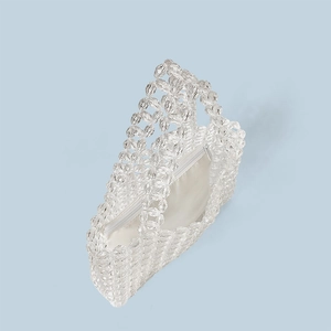 Detail of handmade clear crystal beaded bag featuring intricate flower patterns and lining