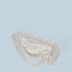 Macro detail of hand-woven clear crystal beads with a white satin zipper lining insert