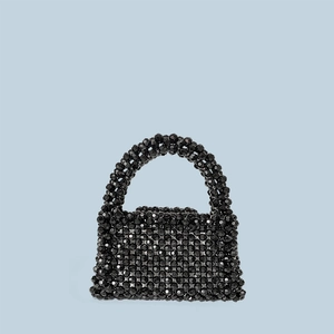 Close-up of handmade black acrylic bead weaving texture on a mini tote bag