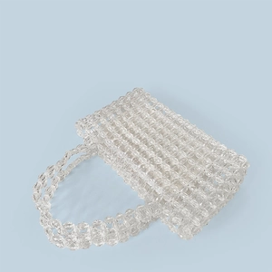 Detailed craftsmanship of clear crystal beaded handbag with intricate woven texture