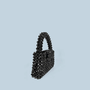 Detailed view of hand-woven mini square handbag with glossy black acrylic beads