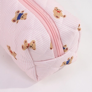 Gros plan d'une trousse à ours matelassée avec rayures roses et fermeture éclair robuste