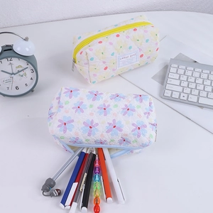 Close-up of quilted floral pencil case with sweet girl label on a white desk