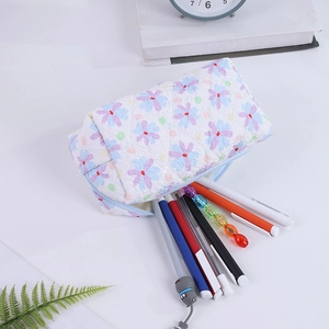 Detail of floral quilted pencil case with soft padding and colorful stationery items