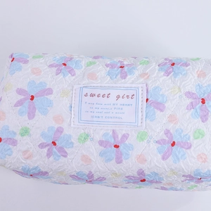 Close-up of quilted floral fabric texture with sweet girl woven label on stationery pouch