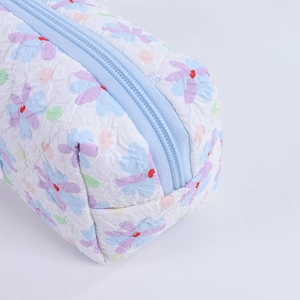 Detail of quilted floral pencil case showing the zipper and soft textured fabric