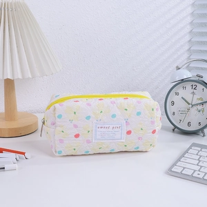 Detail of quilted floral pencil case with yellow zipper and sweet girl label