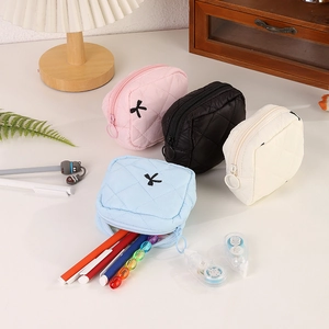 Vista dettagliata di mini pochette trapuntate nei colori rosa, nero, panna e blu