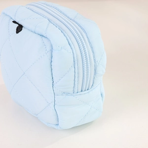 Dettaglio della borsa da trucco in nylon trapuntato azzurro con cerniera e rombi cuciti