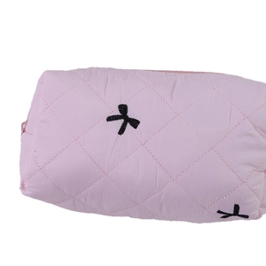 Trousse à maquillage rose matelassée avec broderies de nœuds noirs et fermeture éclair