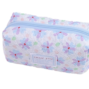 Quilted floral pencil case with blue zipper and sweet girl label on white background