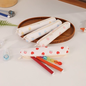 Detail of quilted fabric pencil cases with strawberry prints and soft texture