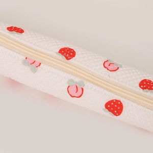 Close-up of strawberry and peach patterns on a textured fabric stationery pencil case