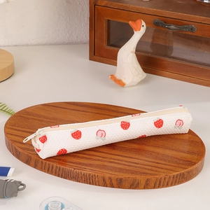 Detail of waffle fabric pencil case featuring red strawberry and pink peach patterns