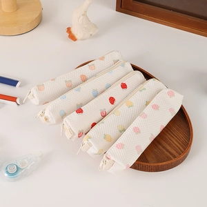 Flat lay of five strawberry print waffle canvas pencil cases on a wooden tray with stationery