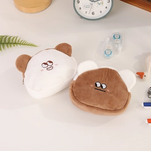 Close-up of two plush bear coin purses with embroidered faces and soft zipper closures