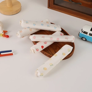 Close-up of quilted strawberry and fruit pattern pencil cases with metal zipper detail