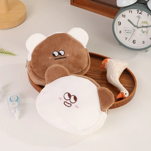 Close-up of soft plush bear coin purses in brown and beige with embroidery details