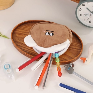 Close-up of brown plush bear coin purse with soft texture and zipper closure on a desk