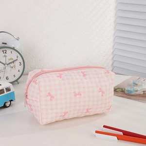 Detail of pink plaid pencil case with bow pattern and quilted stitching texture