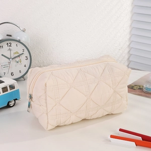 Detailed view of cream quilted nylon pencil case with diamond stitch and zip closure