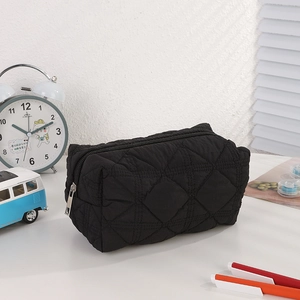Macro shot of the black quilted pencil case fabric and silver metal zipper detail