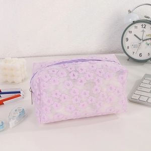 Detailed close-up of purple lace floral embroidery texture on the mesh makeup bag
