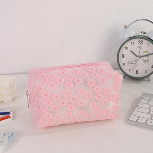 Close-up of pink mesh makeup bag with delicate 3D floral embroidery and zipper detail